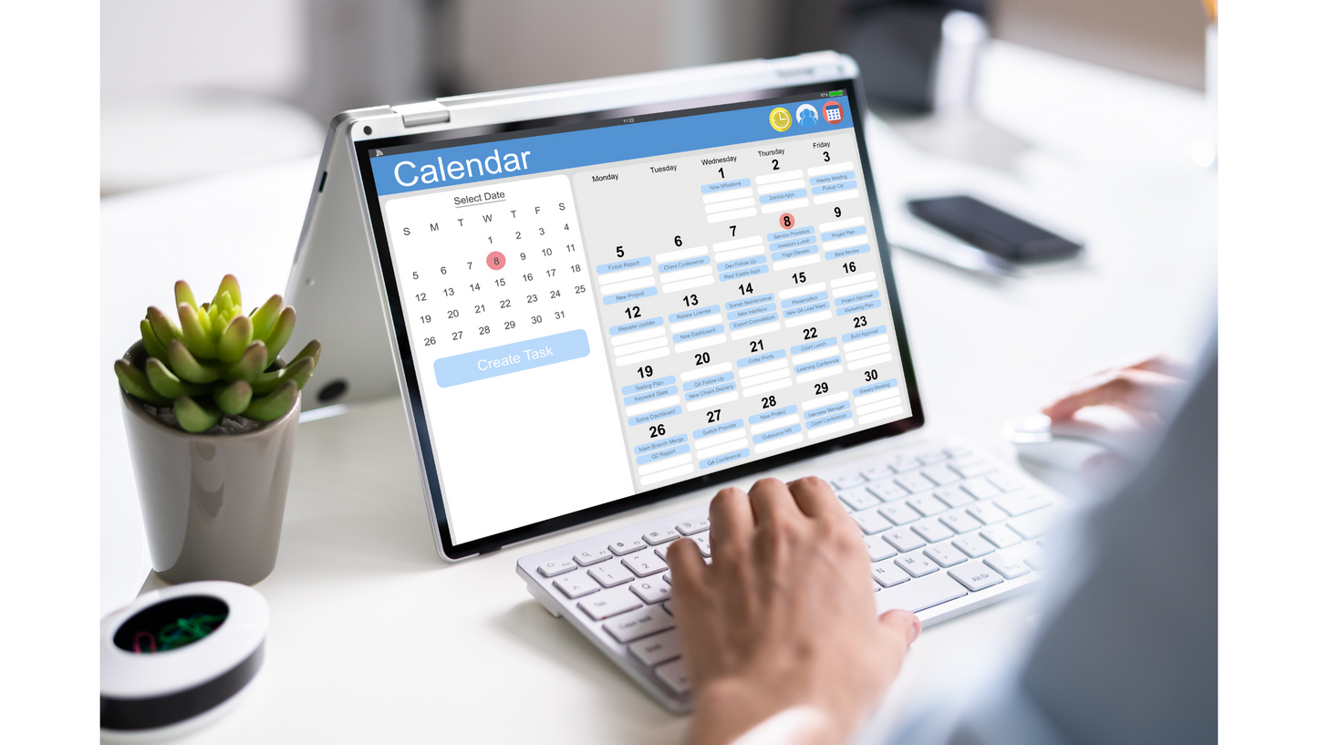 A woman uses her digital calendar on her computer.