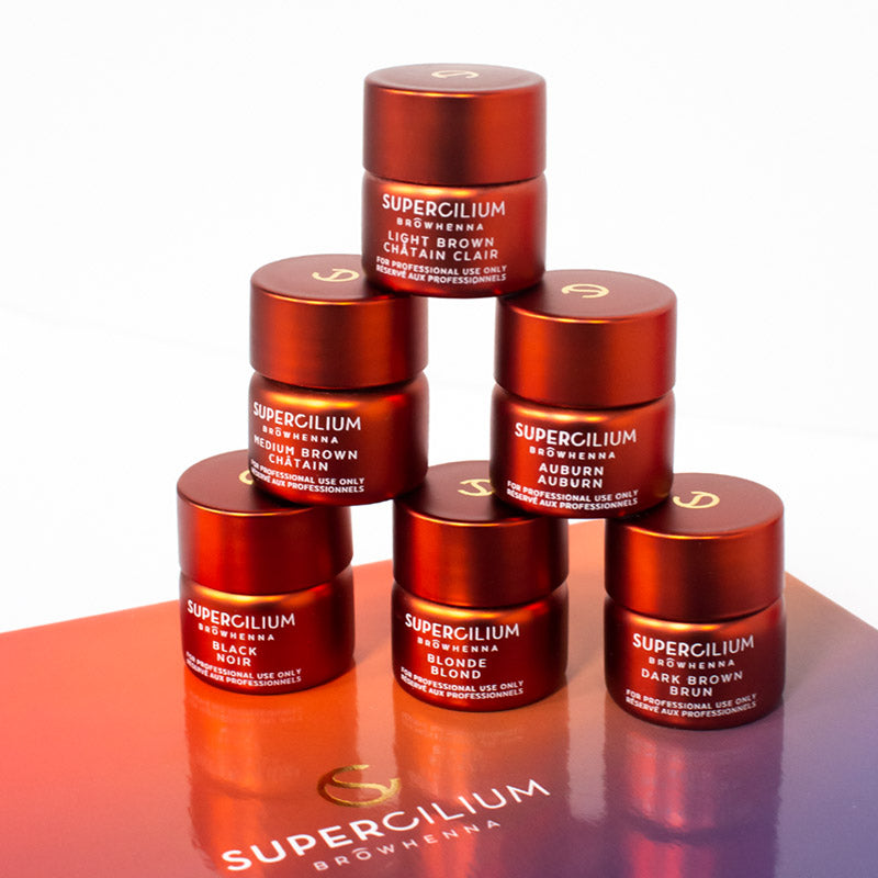 Six small jars of henna from Supercilium stacked on top of one another like a pyramid.