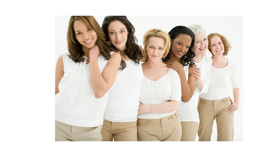 A group of uniquely beautiful women grouped together, smiling.