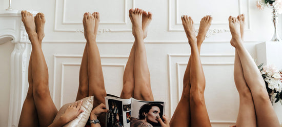 A group of women lay down with their silky smooth legs up in the air.